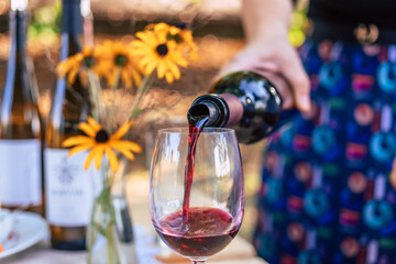 A person pouring wine to a glass