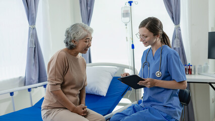 Female doctor with clipboard talking with elderly female patient at hospital Senior woman or doctor with digital tablet Consult or plan treatment to treat medical professionals with female patients.