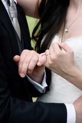 Couple's hands with pinkies intertwined and wedding rings prominently displayed