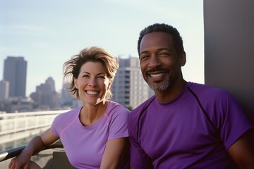 Fototapeta premium Active international middle aged couple, man and woman in sportswear, looking happy while jogging outdoors and exercising together in an urban environment