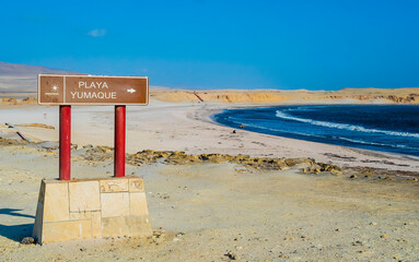 Panoramic view of Yumaque Beach with touristic signboard in foreground, Paracas National Reserve, Peru