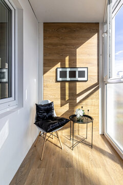 A small loggia in the apartment with a cozy armchair and a coffee table
