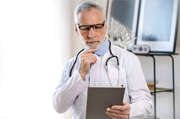 physician man using tablet and looking patient information