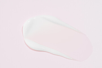 Smear of a face cream or lotion on pink background, cosmetics concept. Beauty face creme smear swatch on color background
