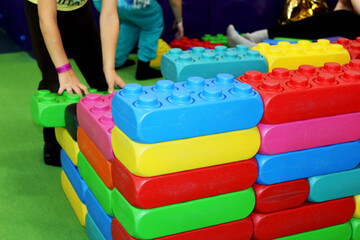a child builds a wall of colorful toy building blocks in a children's center