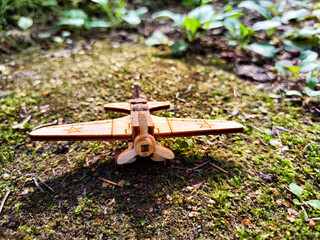Vintage toy wooden airplane with stars on wing in nature. Plane crash, breakdown. Old Soviet glider...
