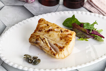 Roasted cod fish steak with salad