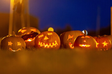 Two boys in the park with Halloween costumes, carved pumpkins with candles and decoration.