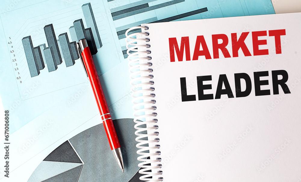 Poster market leader text on a notebook with pen on a chart background