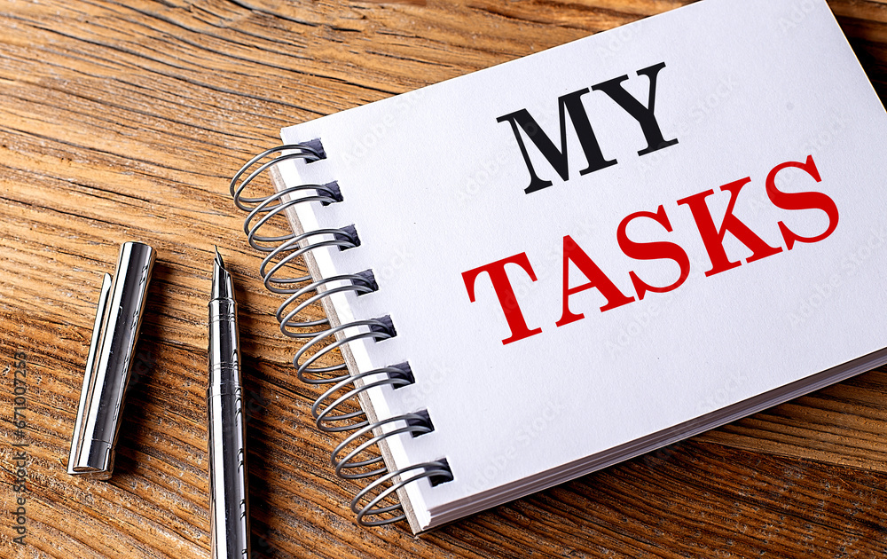 Aufkleber my tasks text on notebook with pen on wooden background