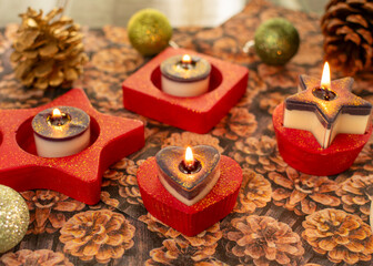 Herz-Teelichthalter mit brennenden Teelicht in rot mit Glitzerstaub. Die Kerzen sind zweifarbig mit...