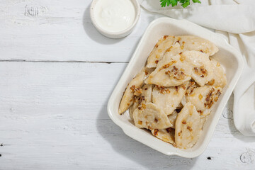 Dumplings, filled with cabbage. Fried onion, fresh sour cream. Traditional Ukrainian dish