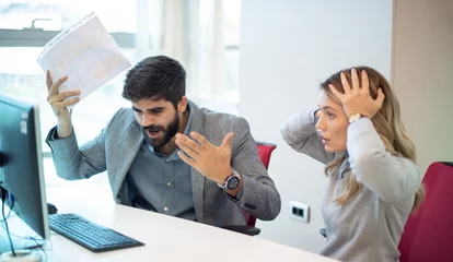Fotobehang Businessman arguing and yelling at his female colleague in office. Abuse and conflict at work concept. Businesswoman with hands on head can't listen her loud superior. Business conflict. © Bojan