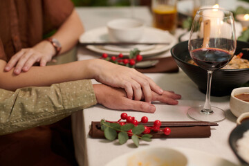 Wife touching hand of husband at Christmas dinner table