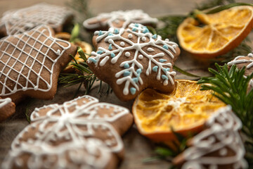 Ręcznie dekorowane ciastka z kolorowym lukrem ułożone na drewnianej desce w świątecznej aranżacji.
