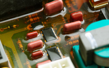 Waterproofed or shock proofed electronic circuit boards and parts. Shallow depth of field. - obrazy, fototapety, plakaty