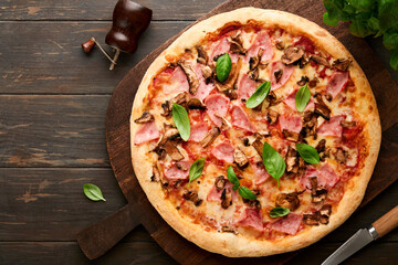 Pizza. Traditional Bacon pizza with ham, mushrooms, pickled cucumber and cheese and cooking ingredients tomatoes basil on wooden table backgrounds. Italian Traditional food. Top view. Mock up.