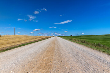 a road through a field with poor infrastructure
