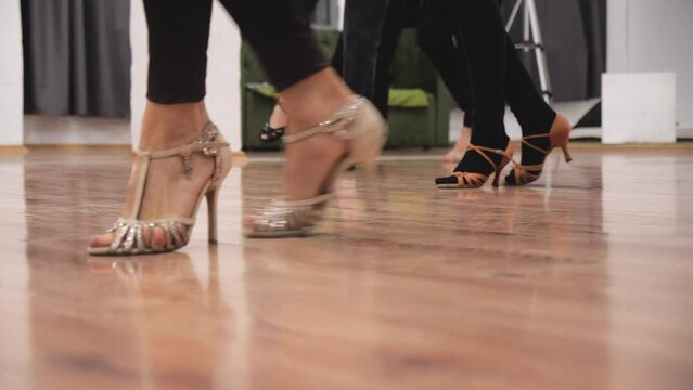 dance lesson. footwork class.  female and male legs in dancing shoes on the floor. high heels. close-up of legs. salsa. mambo. hobby classes for adult dancers