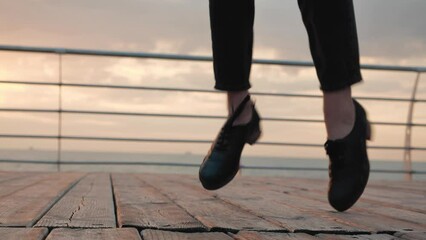 tap dancing person on wooden floor. sunrise sky.  Irish dancing overlooking the sea horizon. dancing shoes