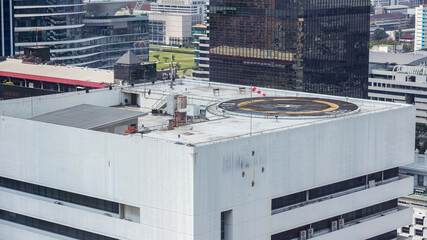 Symbols for helicopter parking on the roof of an office building. Empty square front of city skyline. Offshore helicopter parking pad on an offshore installation platform. - obrazy, fototapety, plakaty