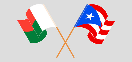 Crossed and waving flags of Madagascar and Puerto Rico