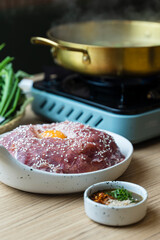 Shabu Shabu or Sukiyaki, a popular dish of pork, beef, and fresh vegetables. Placed on a table with a boiling pot boiling.