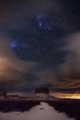 Naklejka na ściany i meble a path leading to a mountain under a night sky with stars