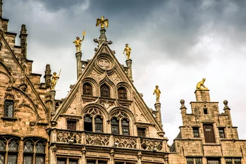 Poster roofs of ancient buildings with gilded figures antwerpen © Elena