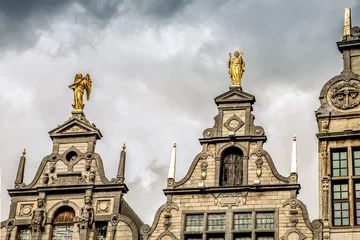 Fotobehang roofs of ancient buildings with gilded figures antwerpen © Elena