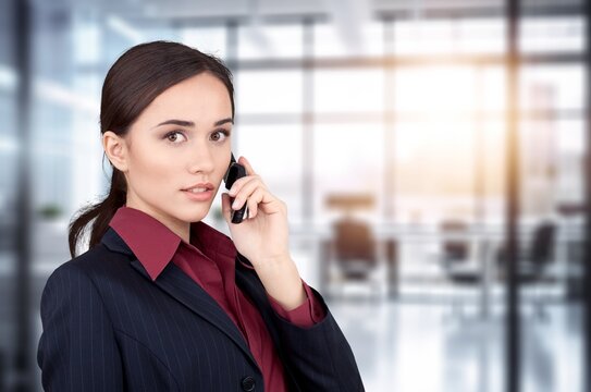 Young businesswoman holding smartphone in modern office, AI generated image