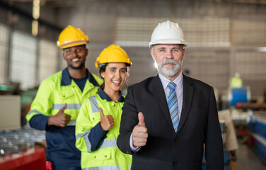 mature older boss engineer with beard mustache on face wear helmet standing smile and hand show good thumb at construction factory site with worker leader team for happy working in factory site.