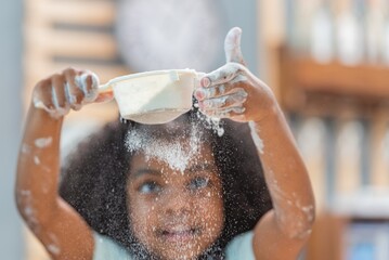 african afro black daughter kids sifting flour powder and sprinkling ingredients on massaging dough for bakery cooking. Black african daughter afro hair enjoy sifting flour wheat by sieve in kitchen