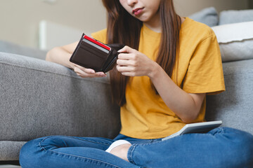 Bankrupt people concept. Close-up view of the hands of a young woman opening an empty wallet on the payday of credit card bills