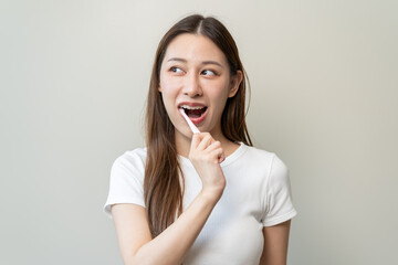 Close-up young woman brushing her teeth isolated on background