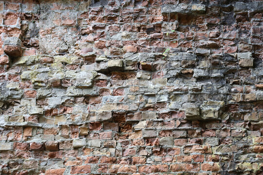 Very old brick stone wall of castle or fortress of 18th century. Full frame wall with obsolete dirty and cracked bricks close up