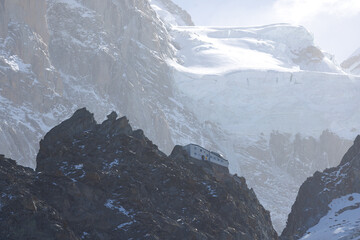 Refuge des Grands Mulets dwarfed by Glacier des Bossons at Mont Blanc, Chamonix