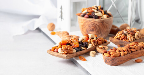 Mix of nuts and raisins on a white wooden table.