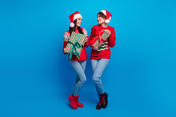 Full length photo of positive charming women santa elves wear ornament pullovers preparing x-mas...