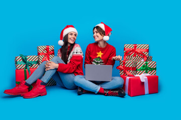 Full length photo of excited funky women santa elves wear ornament pullovers choosing gadget x-mas...