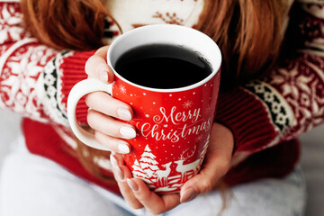Merry Christmas background. Woman drinking coffee. Hands holding red tea mug. Long hair beautiful...