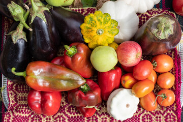 Various vegetables arranged as a background, eggplant, tomatoes, peppers and pumpkins