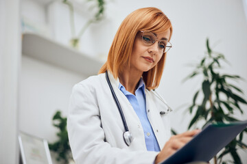 A beautiful female doctor sitting alone in her office, looking at some results.