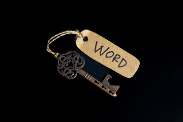 Antique old key with WORD tag on black background