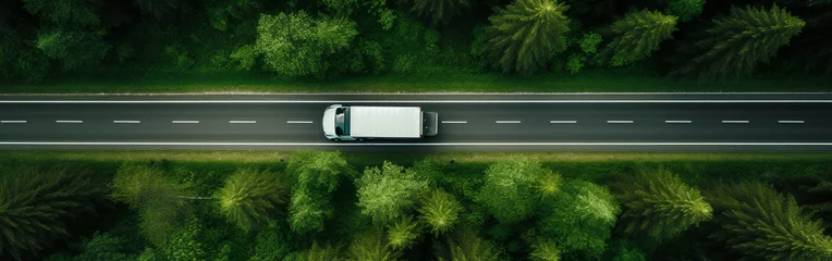 Foto op Canvas Top view of logistic transport truck on the road in the green forest. © Golden House Images