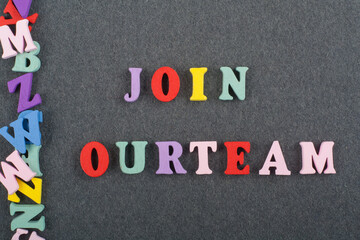 JOIN OUR TEAM word on black board background composed from colorful abc alphabet block wooden letters, copy space for ad text. Learning english concept.