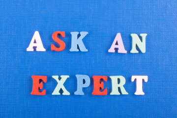 ASK AN EXPERT word on blue background composed from colorful abc alphabet block wooden letters, copy space for ad text. Learning english concept.