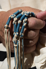 Holding techelet tzitzit during Jewish prayer