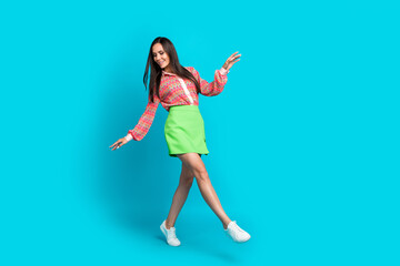 Fototapeta na wymiar Full length photo of beautiful charming woman looking down when she steps in her stylish summer outfit isolated on cyan color background