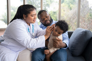 Naklejka premium Pediatric doctor examining ear for a hearing test examining cute little girl in medical healthcare hospital or clinic. Smiling African American Baby whit pediatrician in hospital